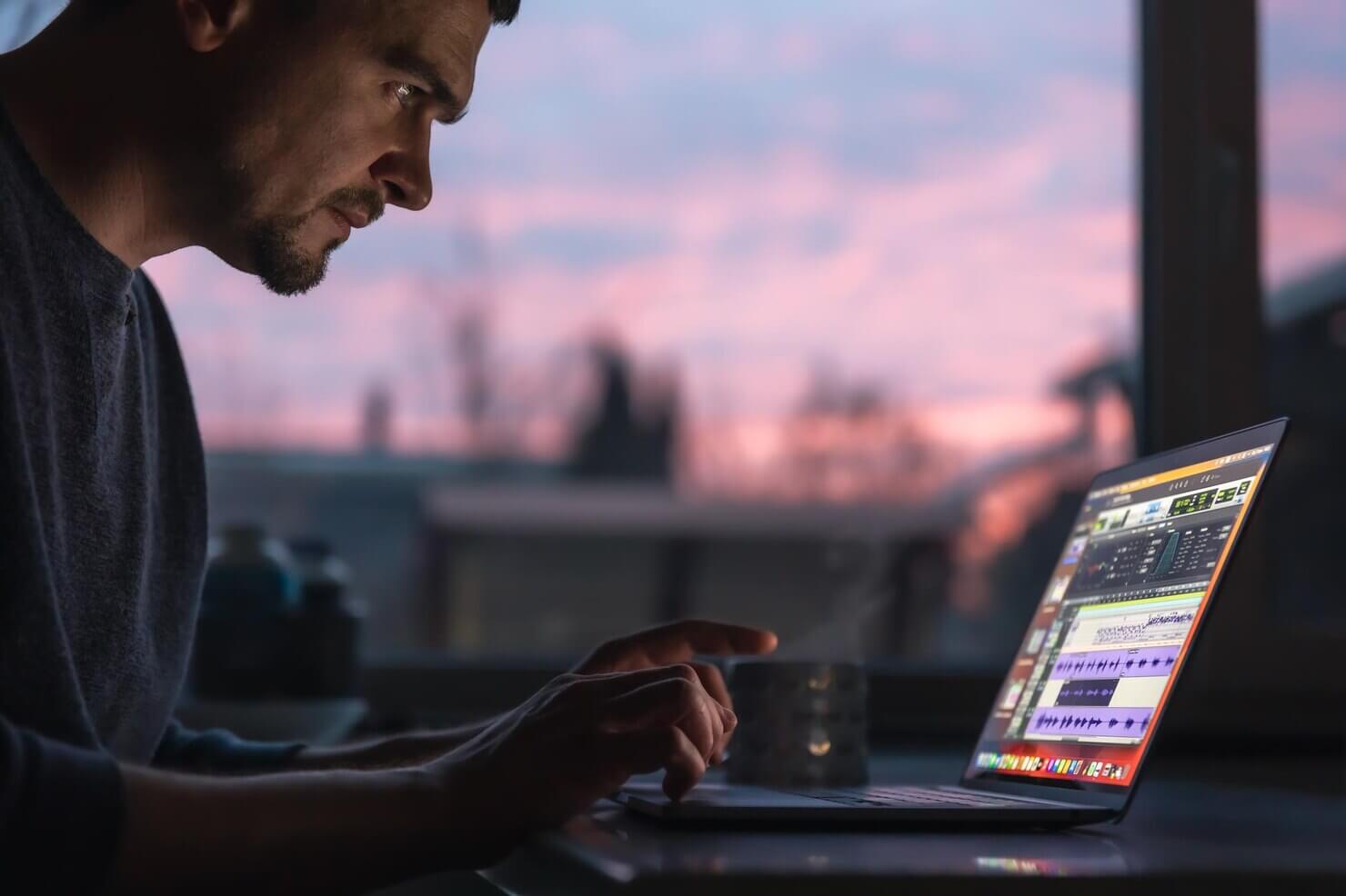 A man works on a laptop early in the morning