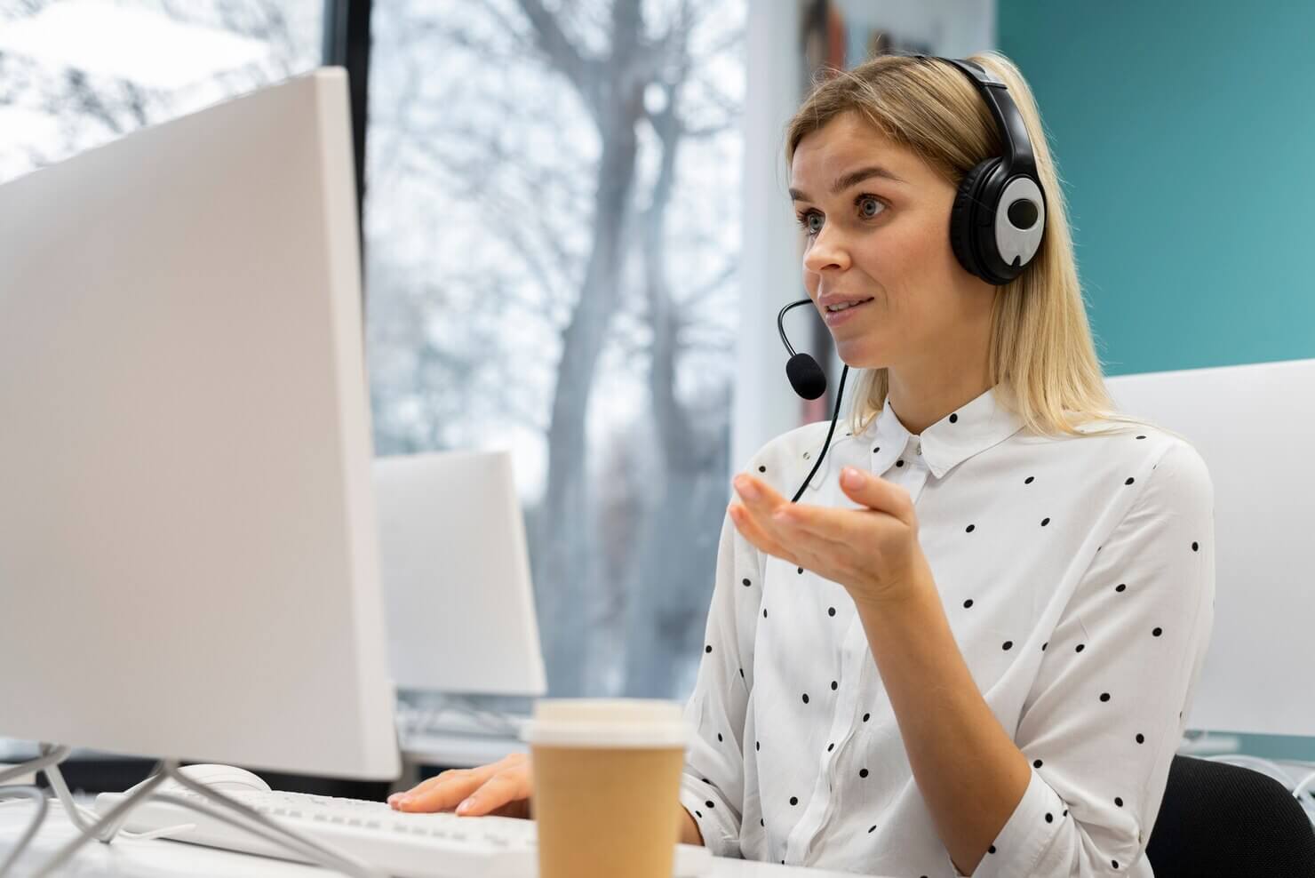 Blond woman working in a WooCommerce Support department with headphones and computer to help client