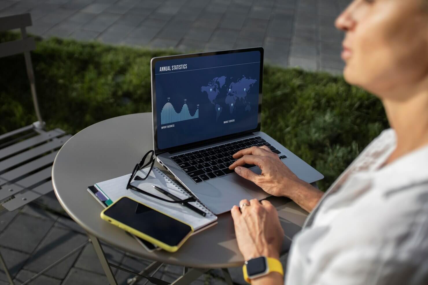 Blonde business woman working on her laptop outdoors. Looking at statisitics for her company website