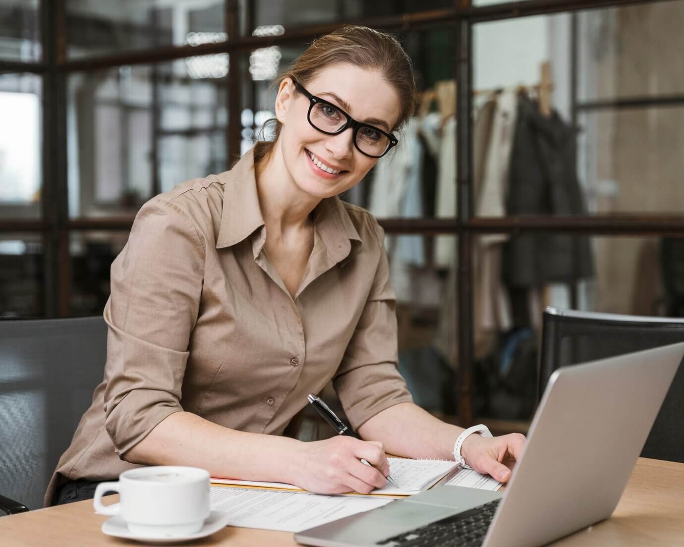 Business woman working on laptop taking notes about website audits in custom WordPress development
