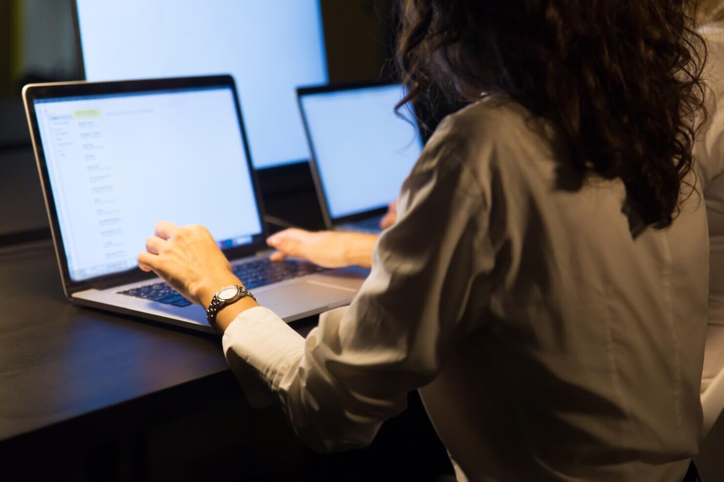 Businesswomen working with laptops. Female programmer working on vertical and horizontal scaling for website