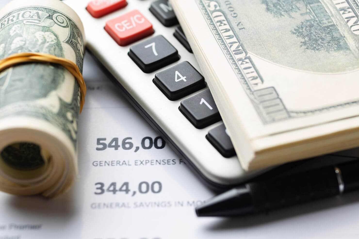 Cash and calculator to add up costs of BigCommerce vs WooCommerce online shops