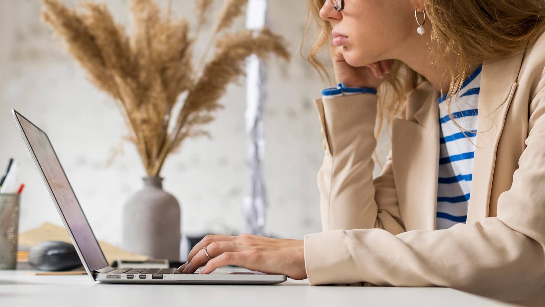 Close-up of female working on laptop creating blog about common misconceptions about WordPress multisite