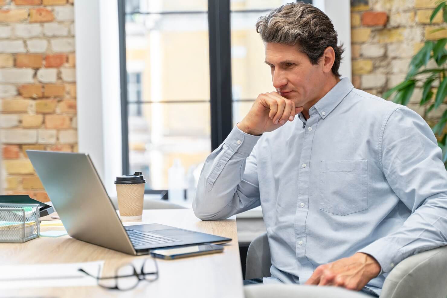 Close up on young businessman looking at website audit trends for 2024 and beyond