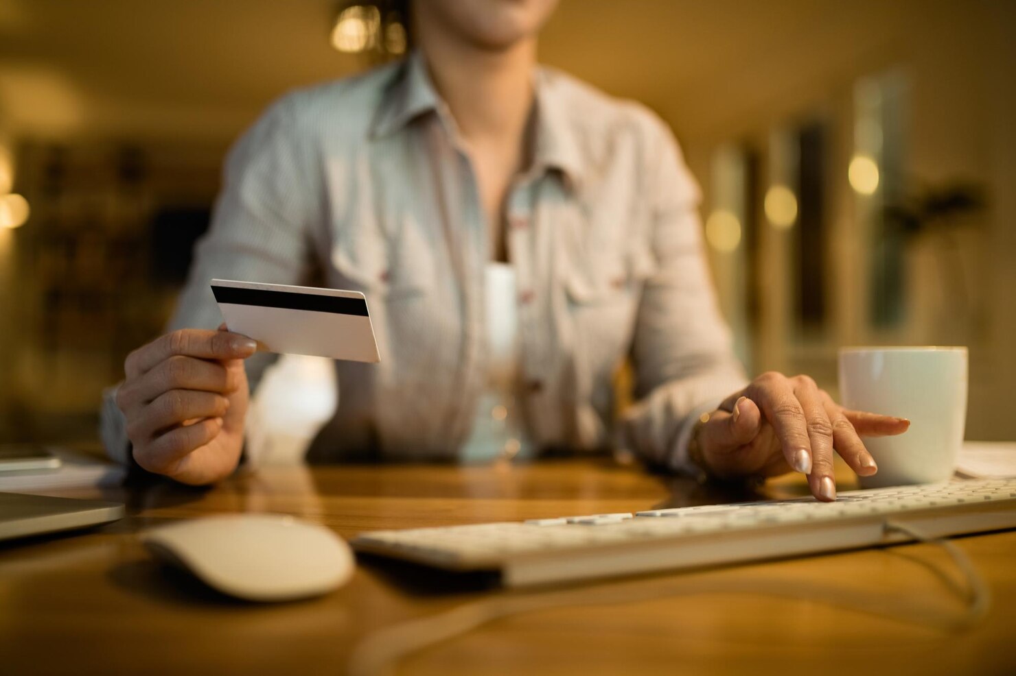 Closeup of woman using computer and credit card for online shopping in the evening at home. WordPress for blogging vs business