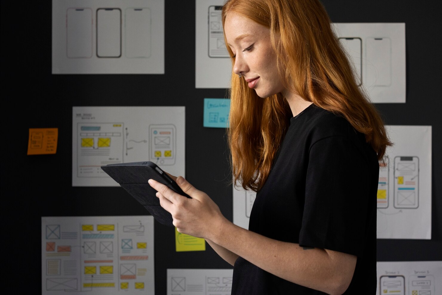 Female web designer in the office with notebook looking at usability test results to modify her design
