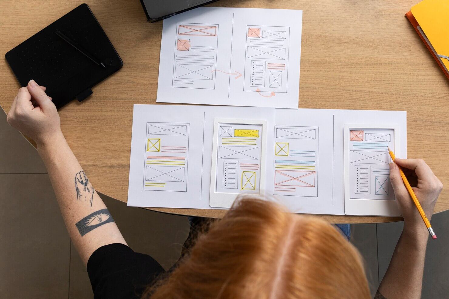 Female web designer in the office with notebook. She is planning out two different web pages to test out for search traffic