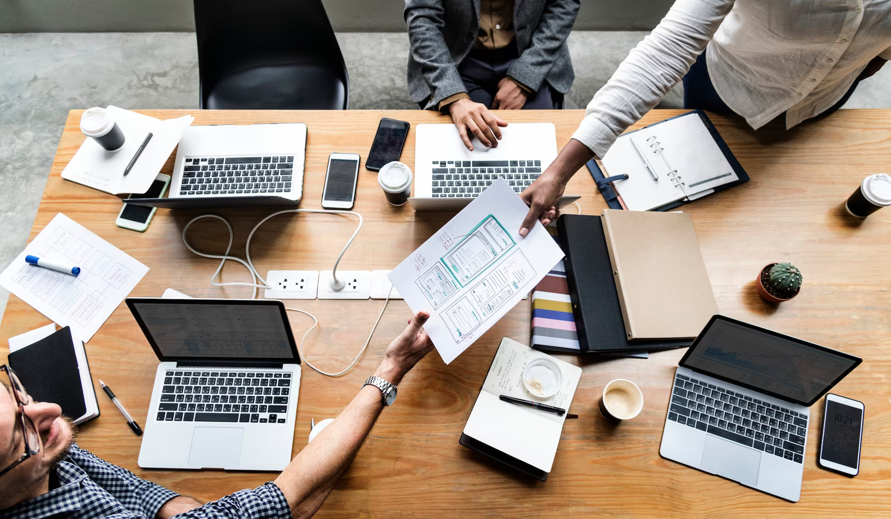 Group of people working on website template for a website. Using a visual composer and paper designs