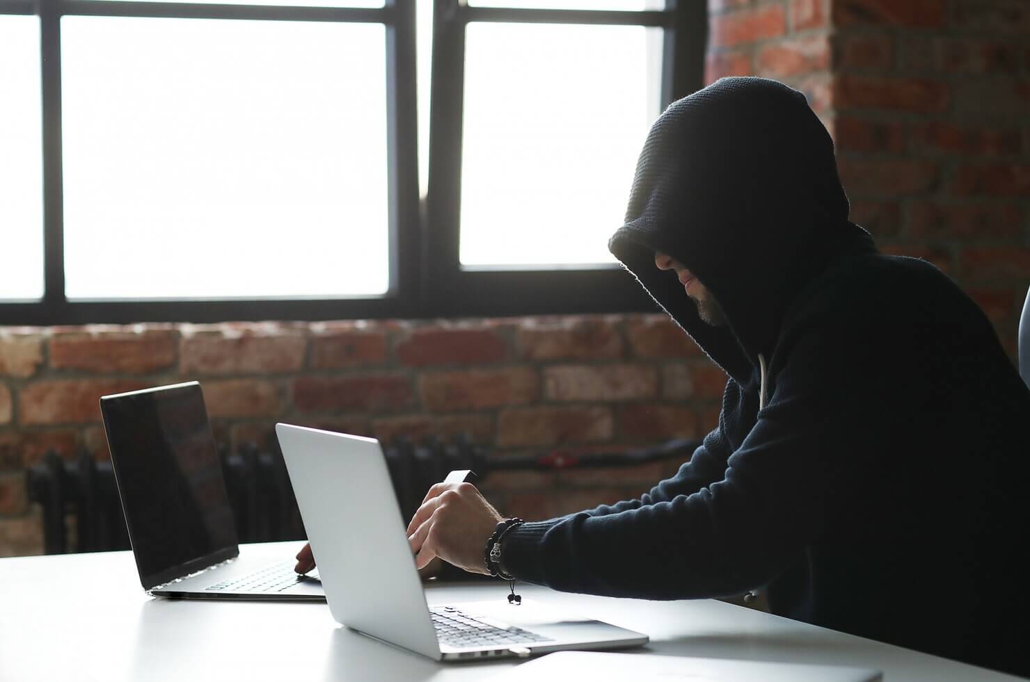 Hacker man on laptop, taking advantage of security issues on site