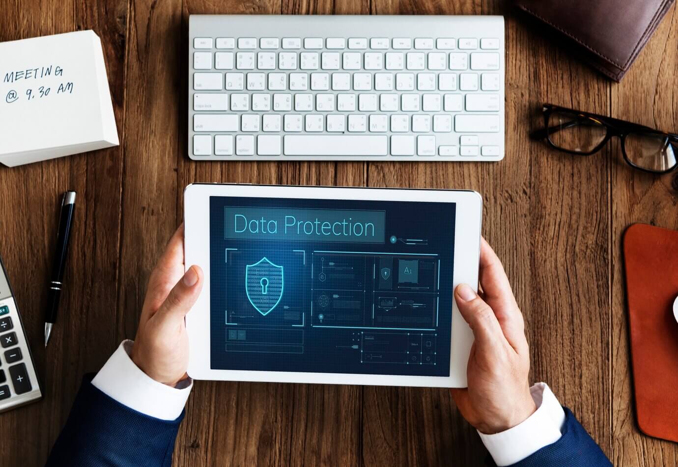 Hands working on digital device network on tablet. Data protection policy