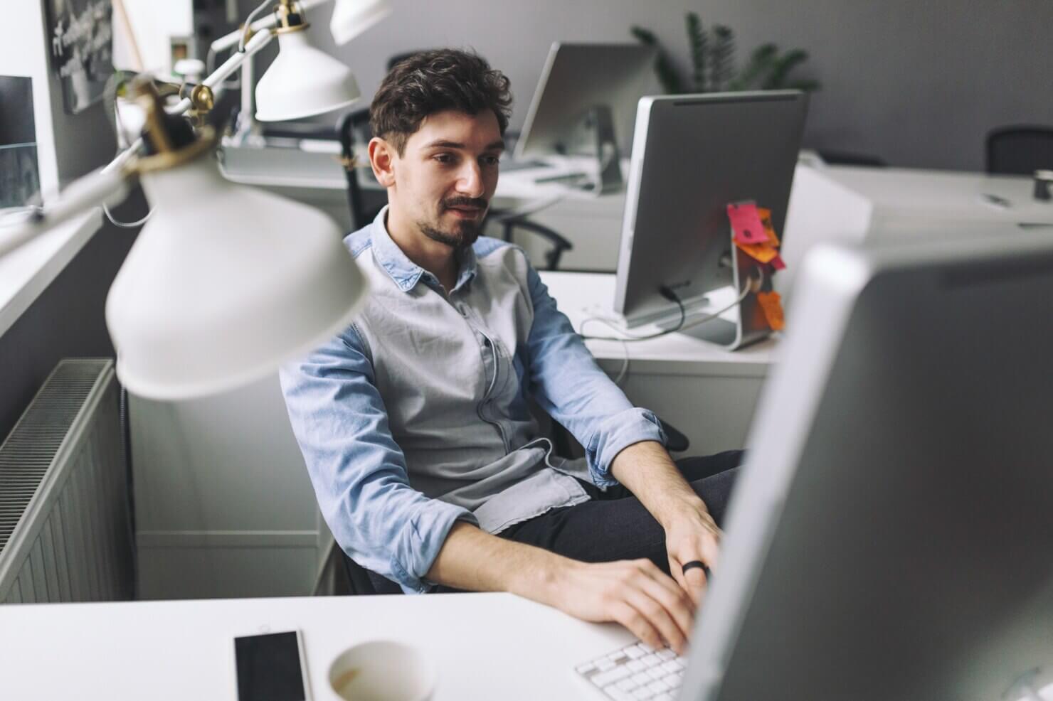 Handsome businessman working in office. Typing up a report about fun facts about WordPress support