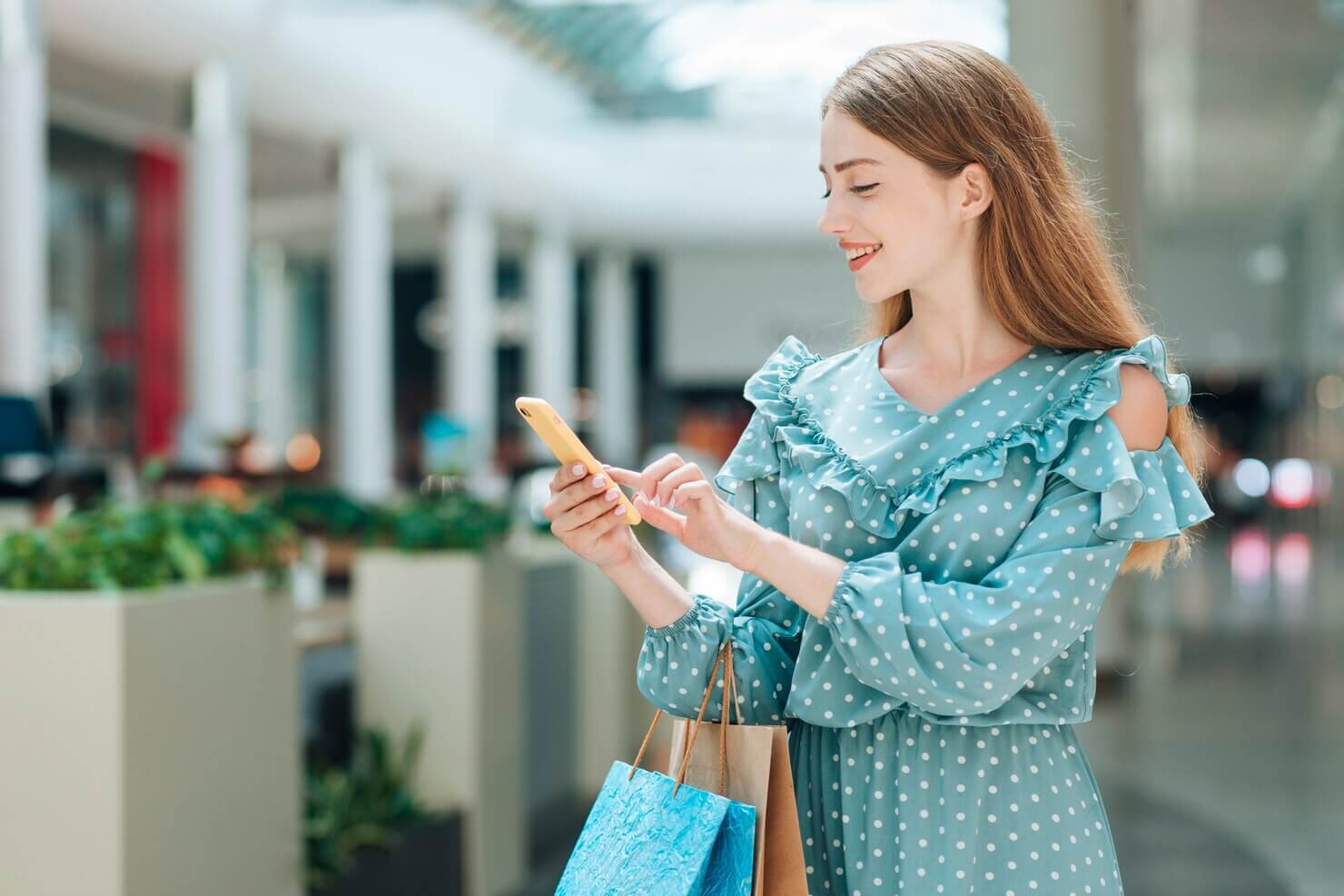 Happy customer doing some online shopping in a mall