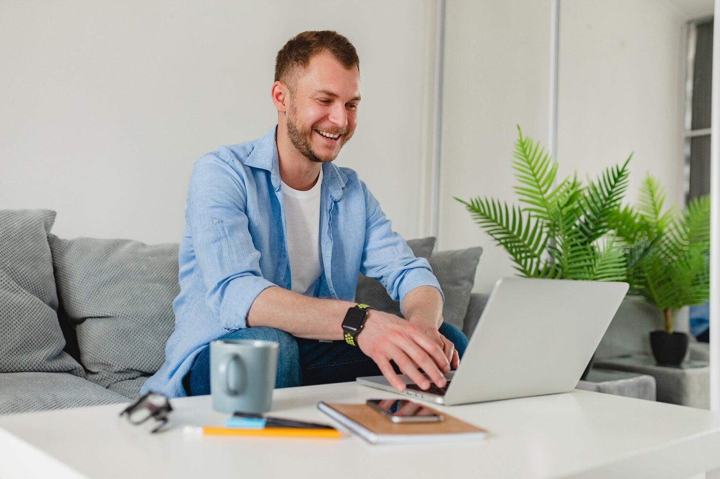 Happy man working from home & reading about the pros and cons of using page builders in WordPress development