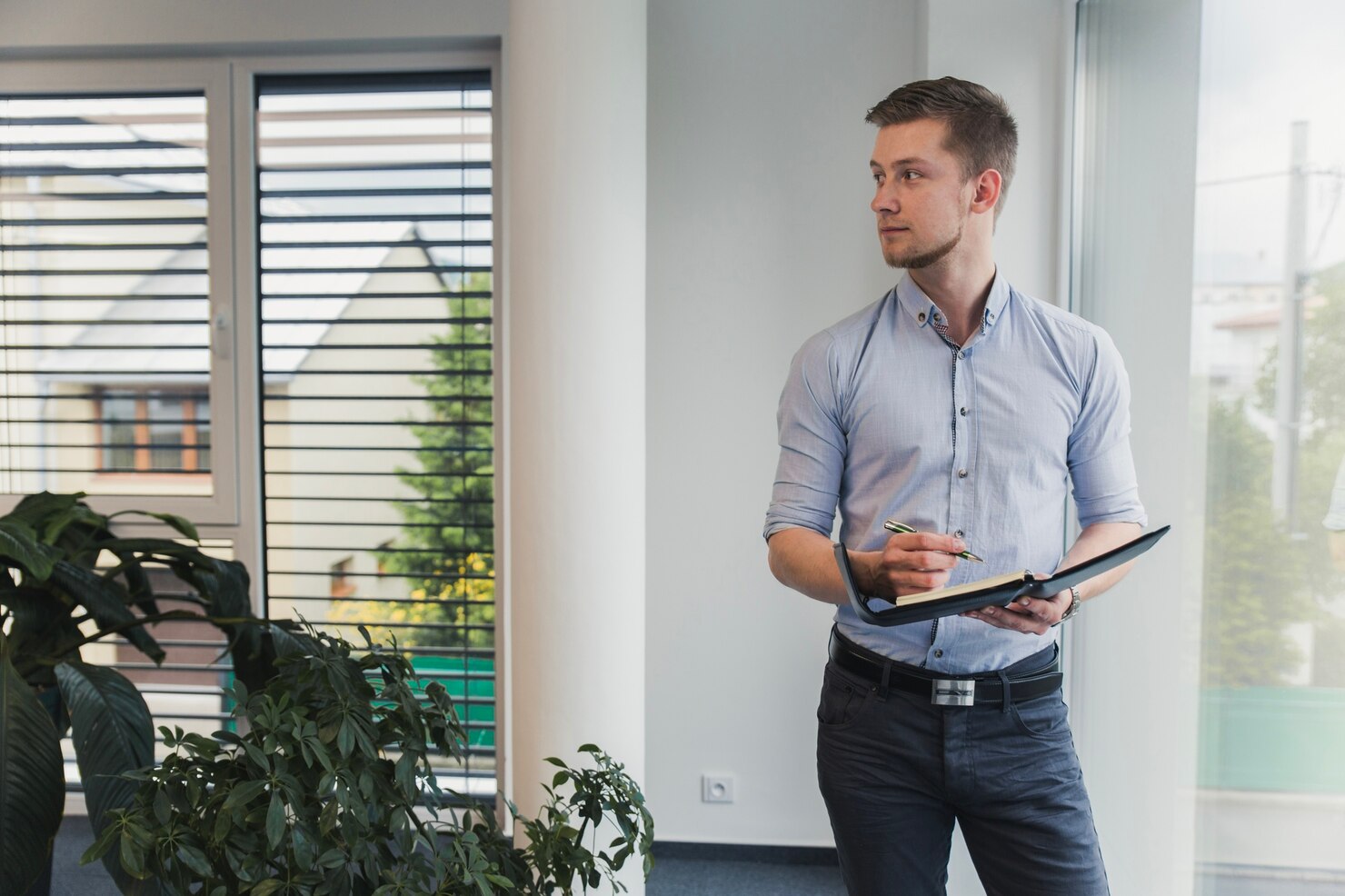 Male worker with notepad in office, he is developing a WordPress disaster recovery plan