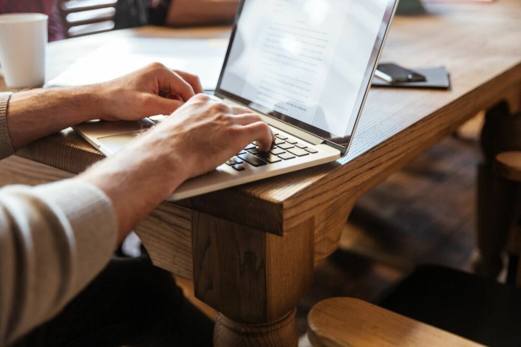 Man creating a document on his laptop about the benefits of a one page WordPress website.