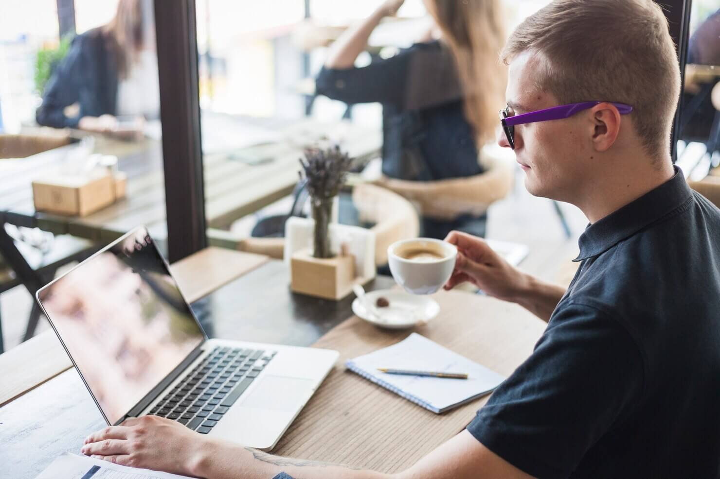 Man drinking coffee at wooden table with laptop. He is happy with user experience due to native lazy loading