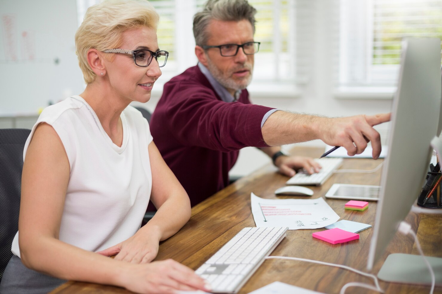 Man helping his partner at work. Fun facts about WordPress Support, developers act as educators