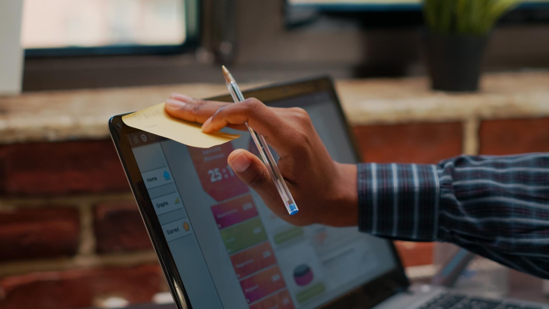 Man putting stifcky note on his laptop screen with benefits of unlimited wordpress support