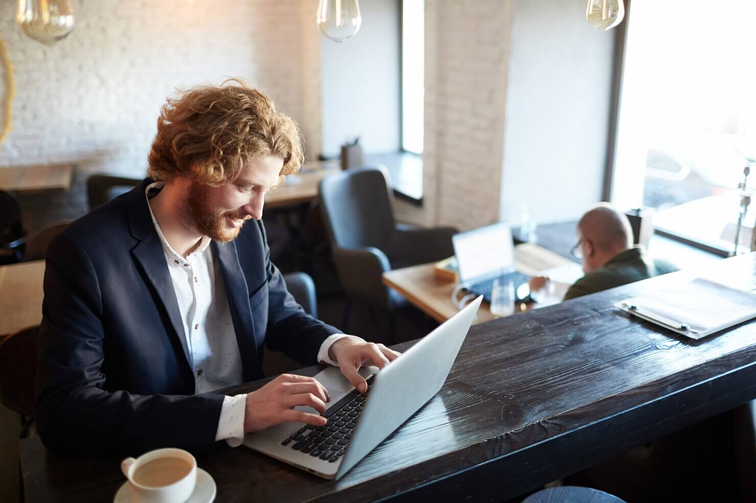 Man working at the coffee shop on creating a document about Worst WordPress security mistakes
