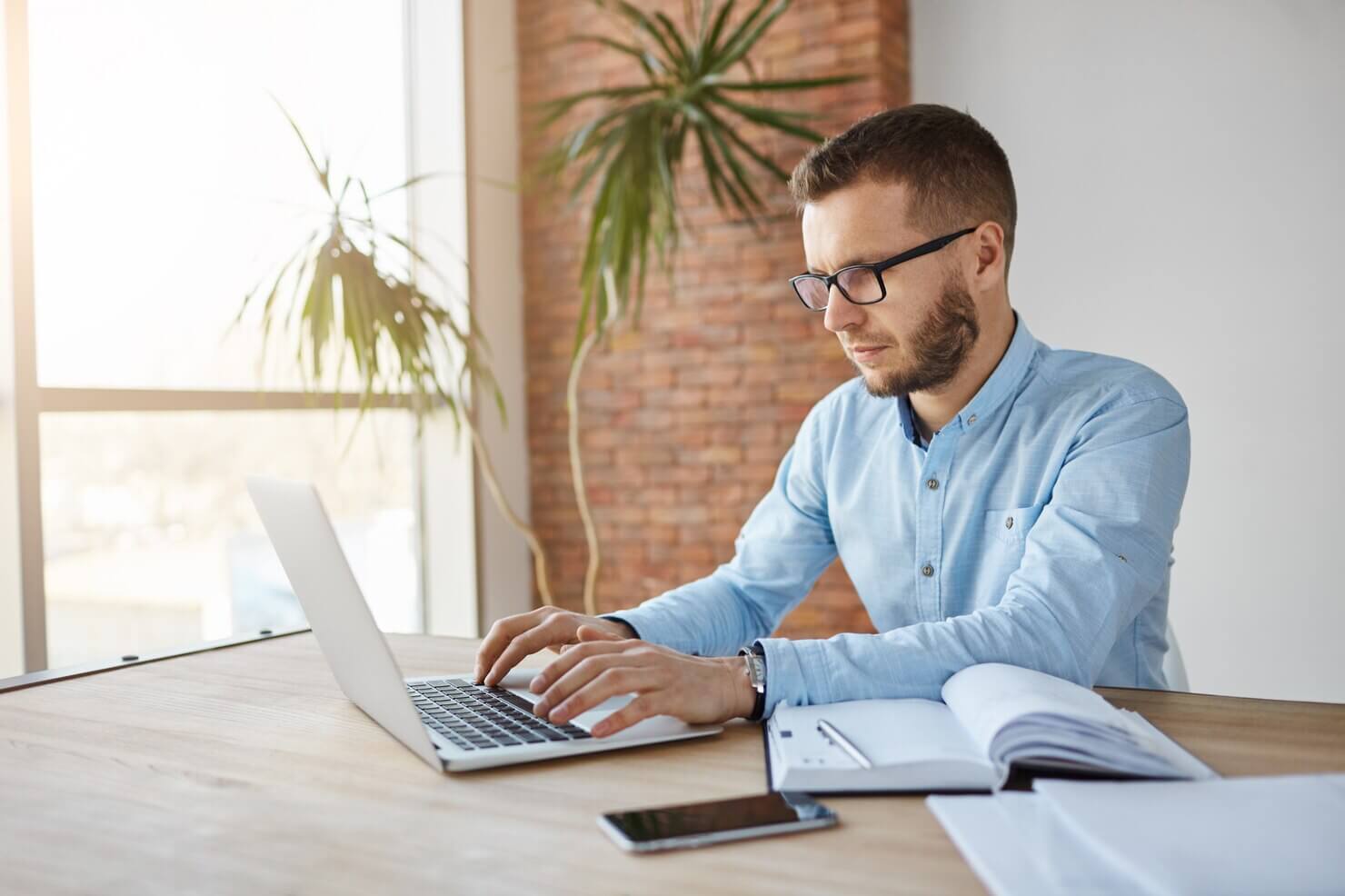 Man writing out best practices for pop-ups and CTAS. Auditing website pop-ups and ctas
