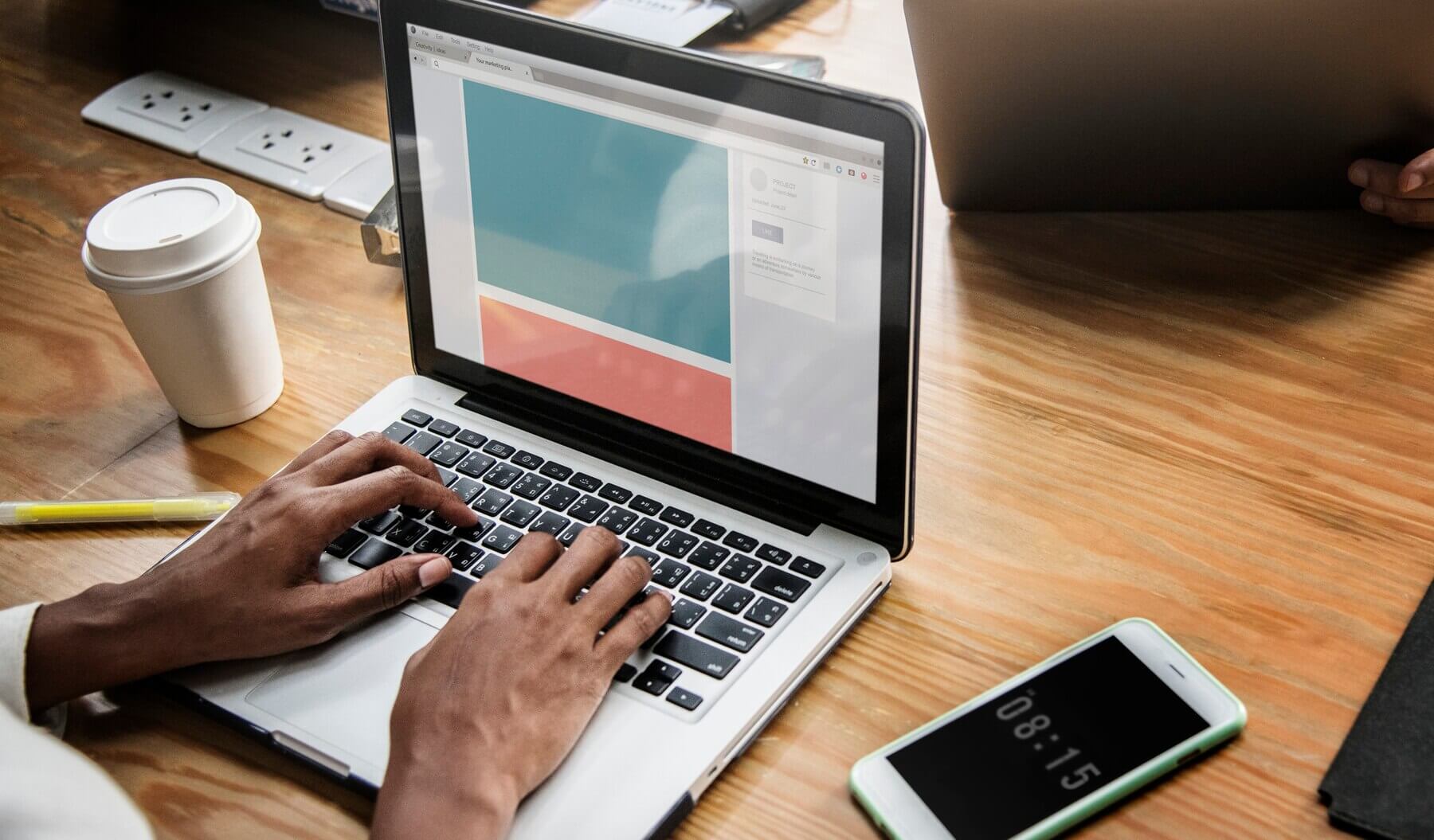 People working on a laptop in a meeting to make sure that website is up-to-date and error free