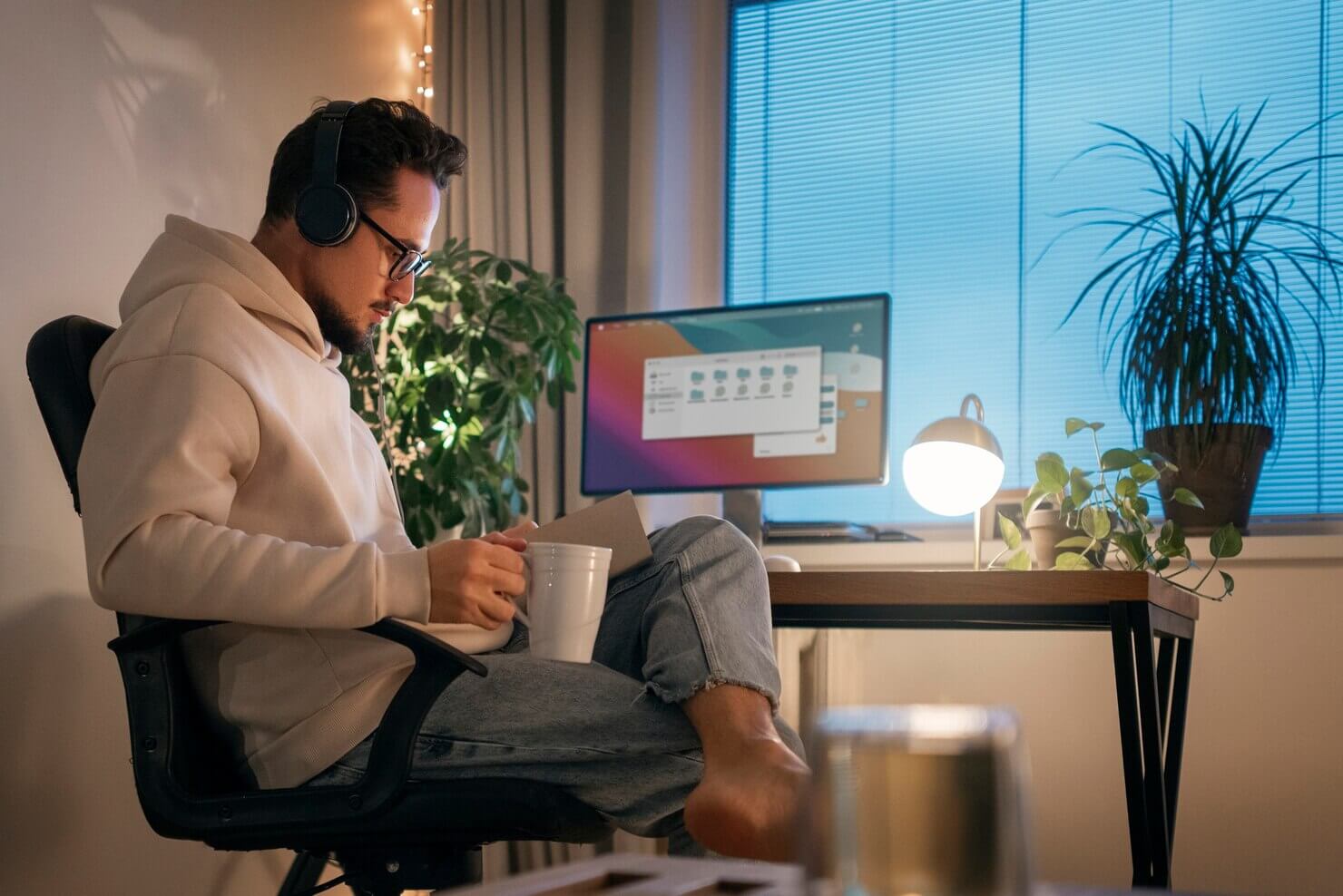 Person at home working late at night. Man is organzing files to move to managed WordPress hosting providers. He is working on a scalable WordPress site