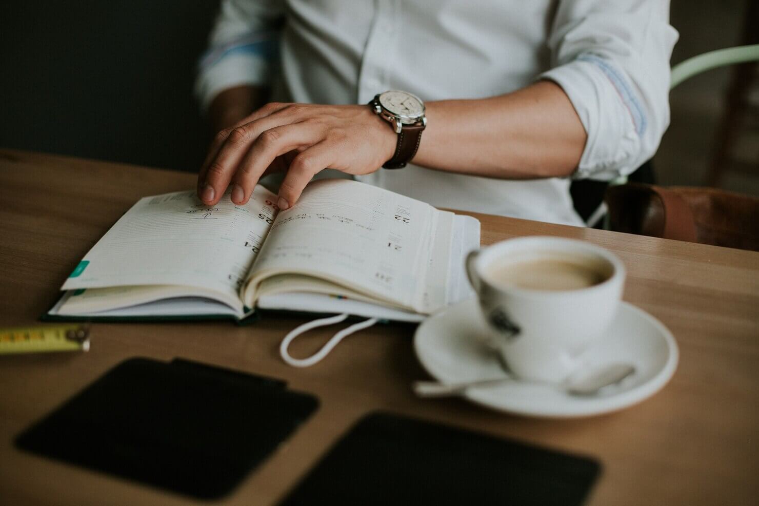 Person taking notes on unlimited support vs hourly woocommerce help in a notebook while working from home