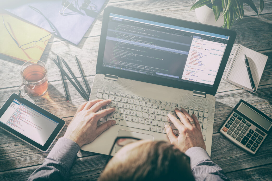 Person using laptop and tablet for designing for conversion rate optimization