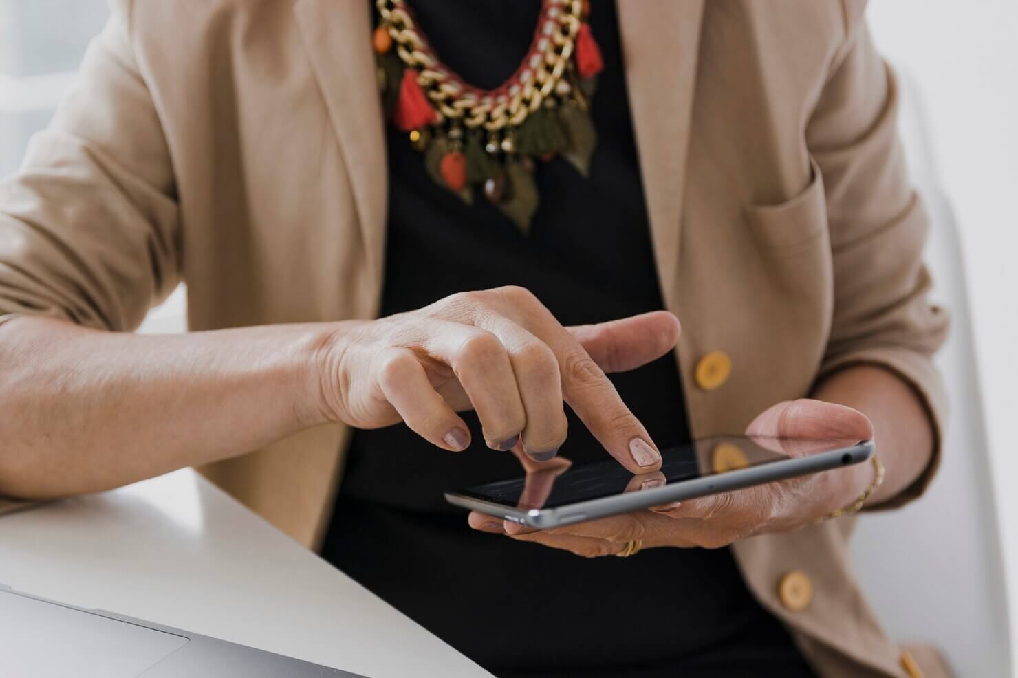 Person with necklace touching a tablet looking through plugins top optimize WordPress site for mobile SEO