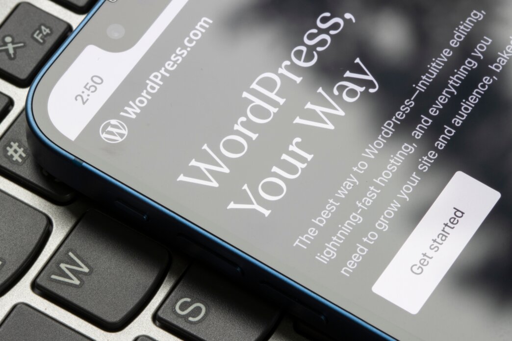 Pros and cons of using page builders in WordPress development. WordPress opened on a mobile device, get started now