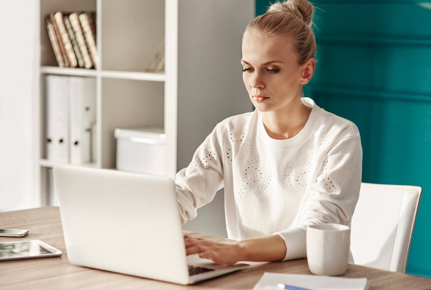 Serious woman with laptop researching potential WooCommerce support providers
