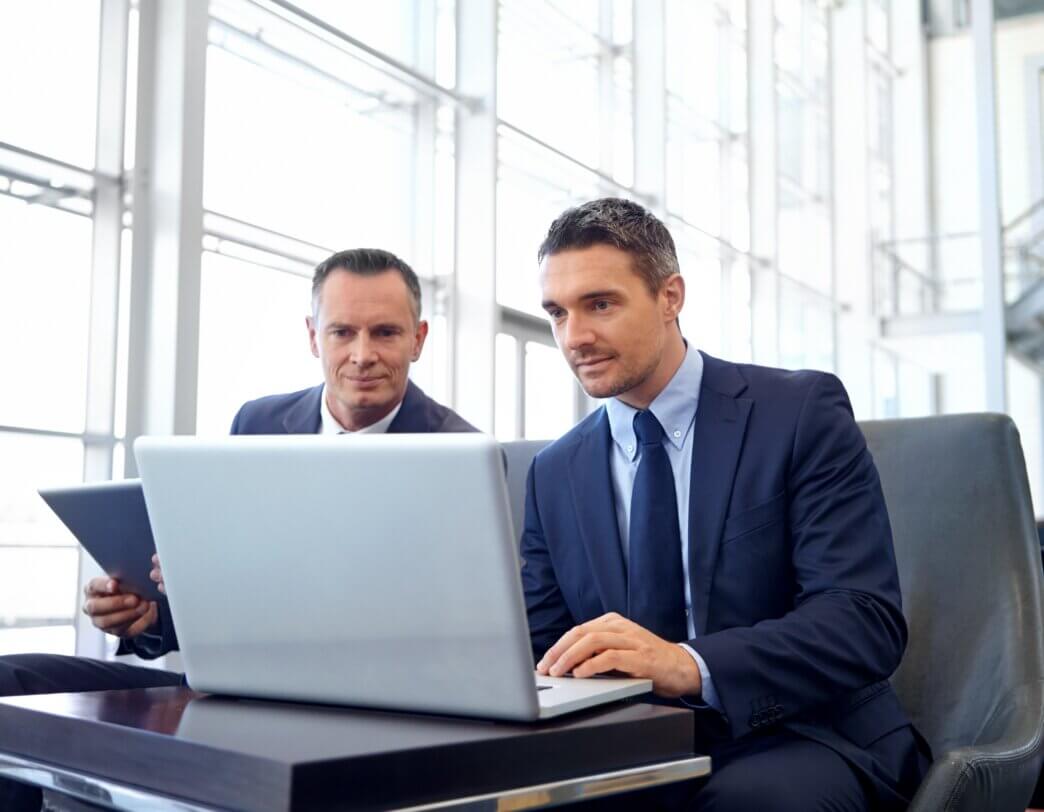 Two business men working on setting up automated WordPress maintenance for their business site
