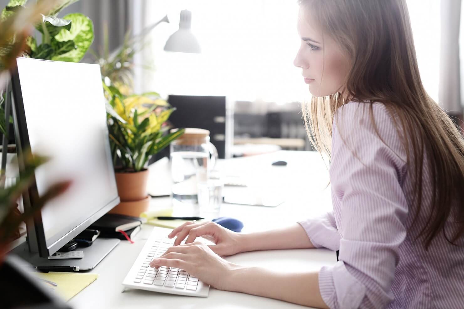 Woman in the office working on computer to create a report about WordPress and GDPR compliance
