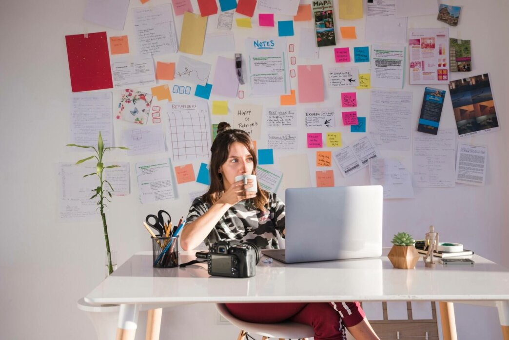 Woman reading about crafting content based on content audit. She is drinking her coffee in a home office