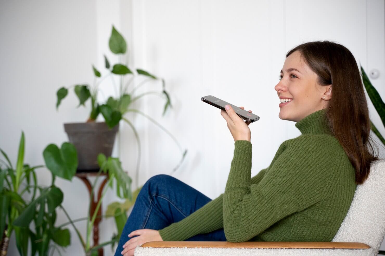 Woman talking on her smartphone while being at home using the handsfree feature. She is using voice search