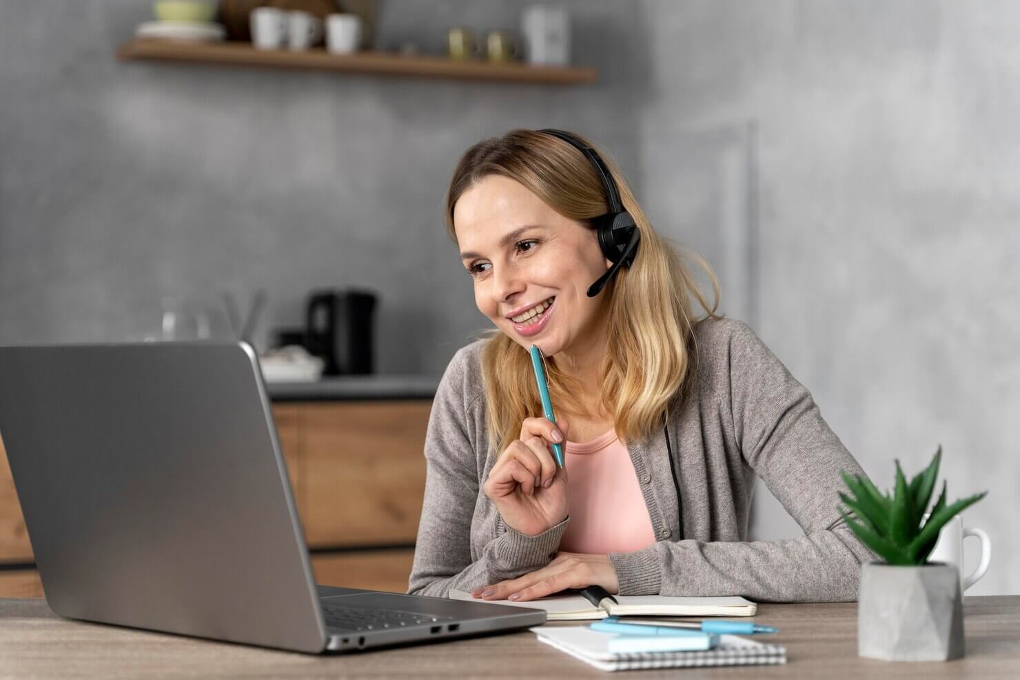 Woman with headset working on laptop. WordPress support video chats and other multimedia