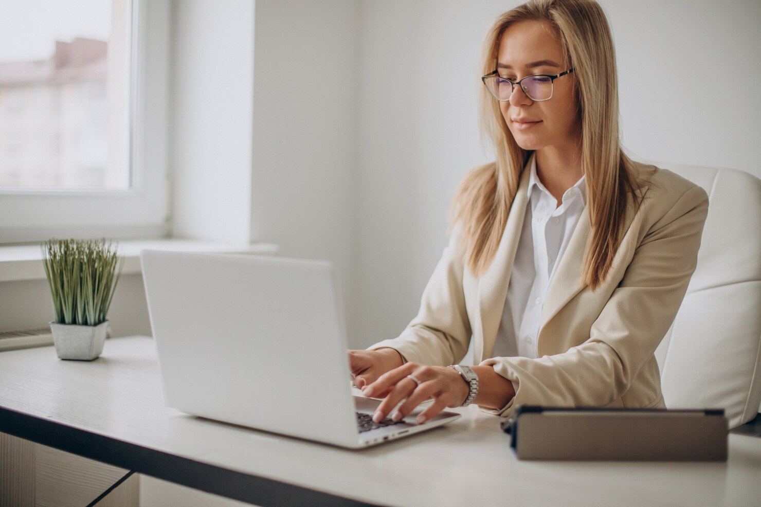 Young business woman working on computer in office. She is creating a report on technical debt in WordPress sites