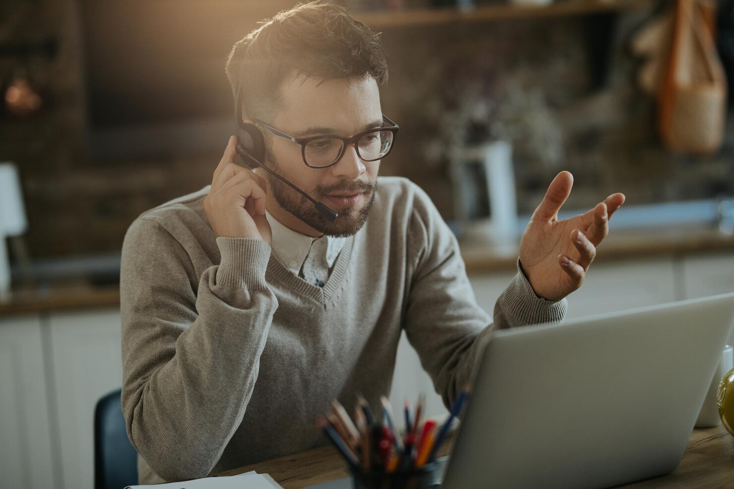 Young entrepreneur having conference call over a computer while working at home. Easier maintenance with consistent UI elements and UX design