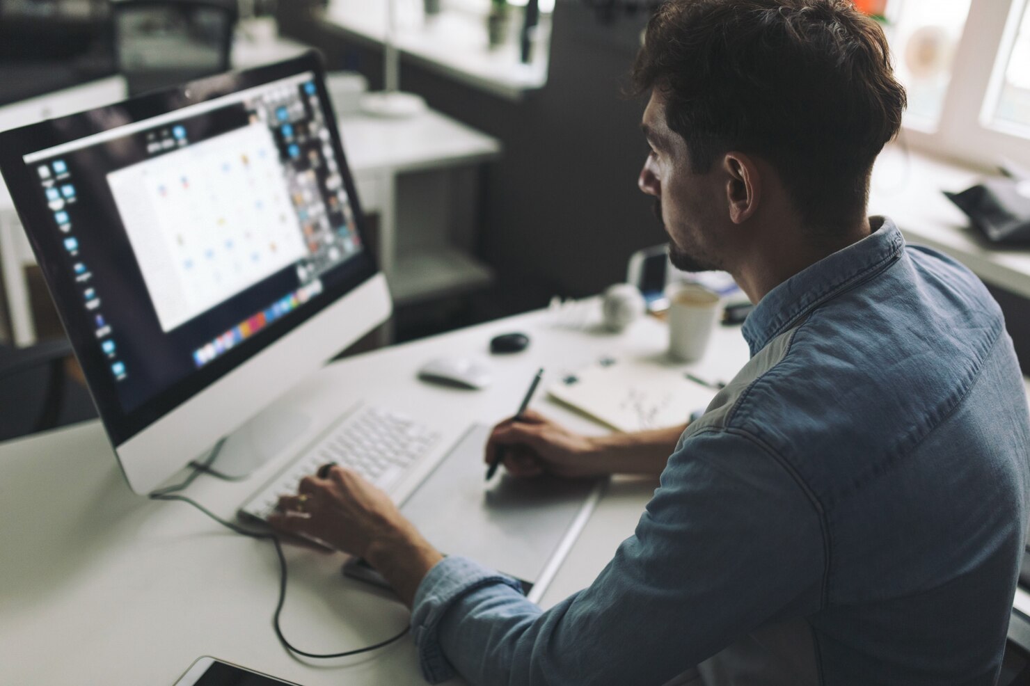 Young graphic designer working in office on site editor to create Figma website