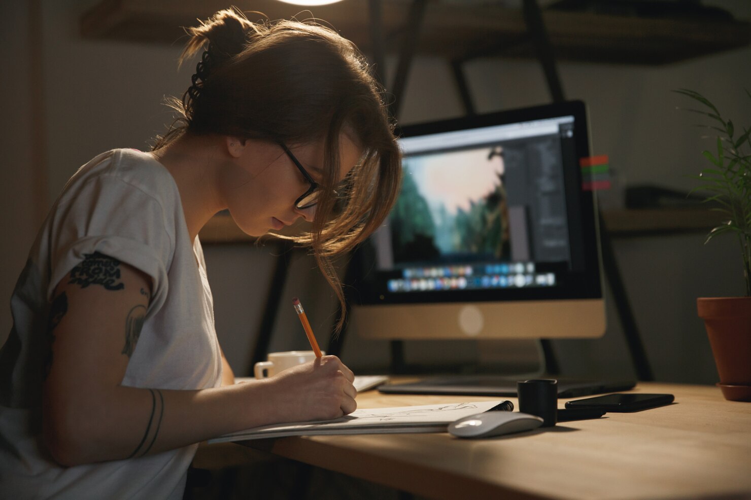 Young woman designer sitting indoors working on desigining for conversion rate optimization